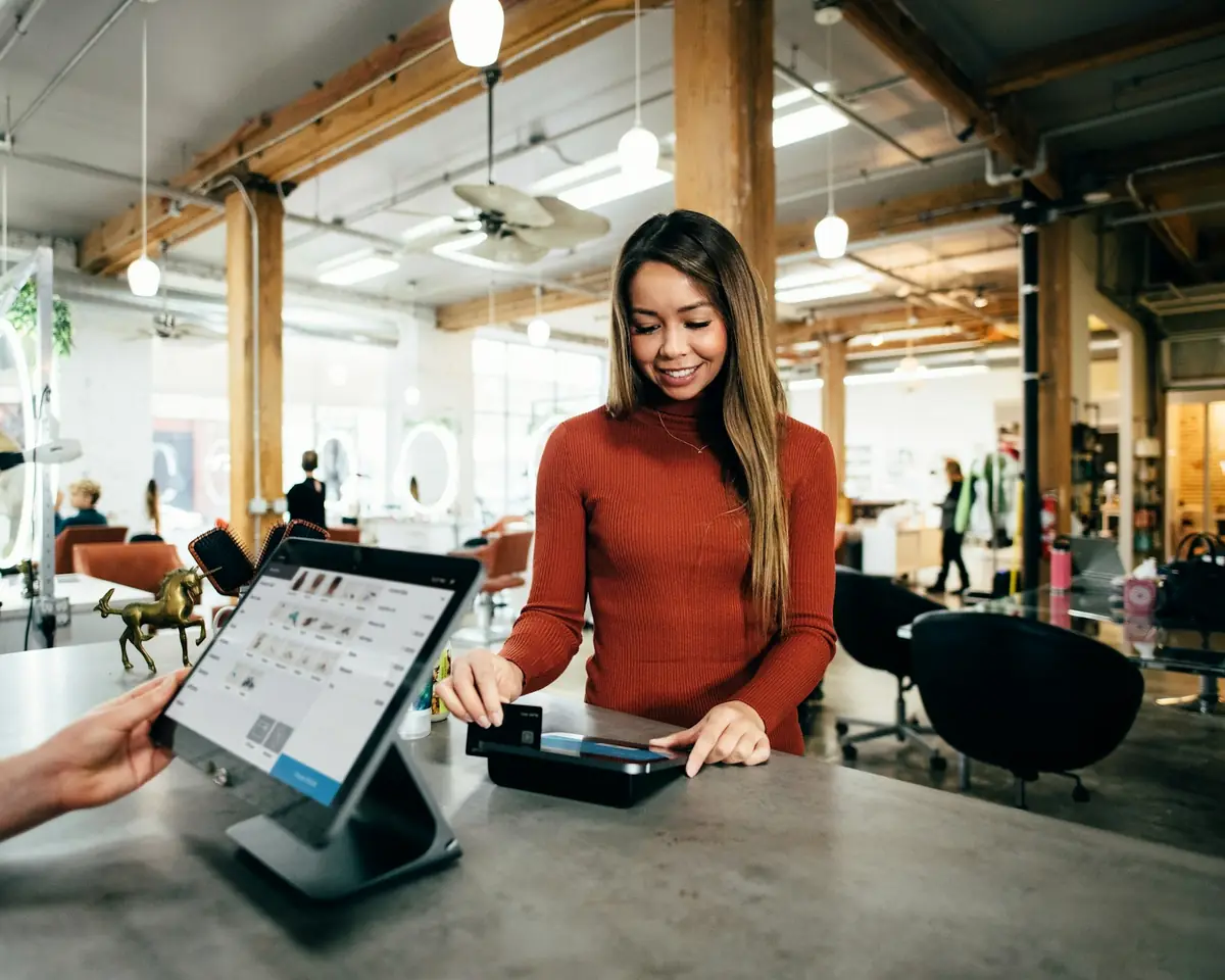 Store owner processing a customer order on a tablet point-of-sale checkout